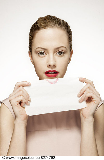 Portrait of woman blotting lipstick on tissue