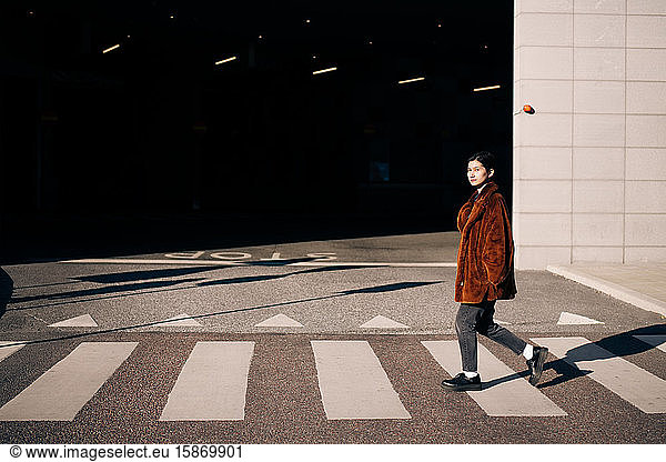 Portrait of woman crossing road