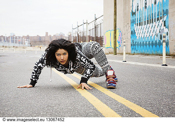 Portrait of woman exercising on road