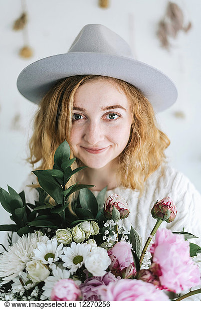 Portrait of woman holding bunch of flowers  looking at camera smiling