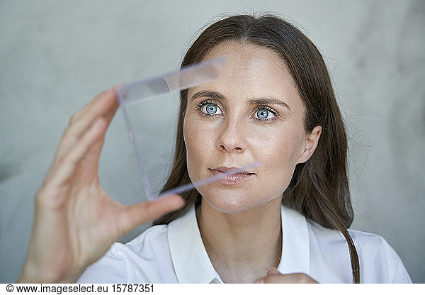 Portrait of woman looking at transparant cube
