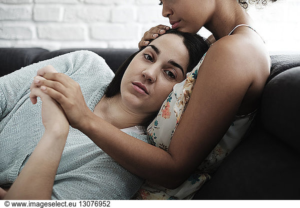 Portrait of woman relaxing on girlfriend's chest at home
