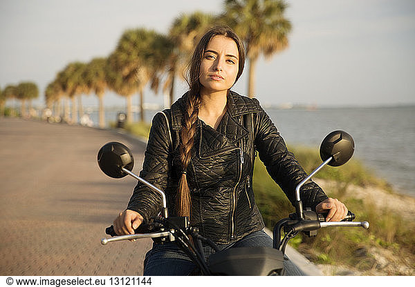 Portrait of woman riding motorcycle on street