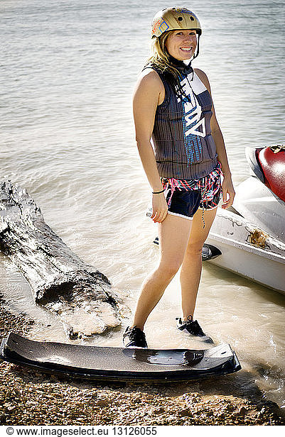 Portrait of woman standing at shore by jet boat
