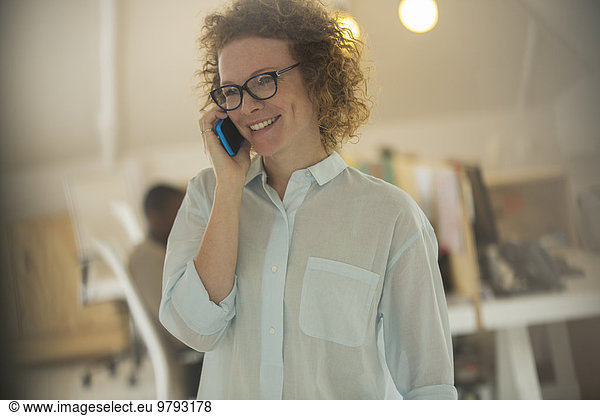 Portrait of woman talking on phone at office