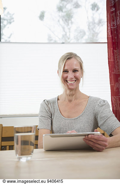 Portrait of woman using digital tablet  smiling