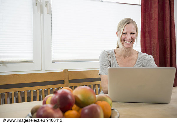 Portrait of woman using laptop  smiling