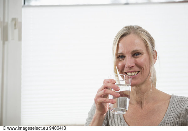 Portrait of woman with glass of water  smiling