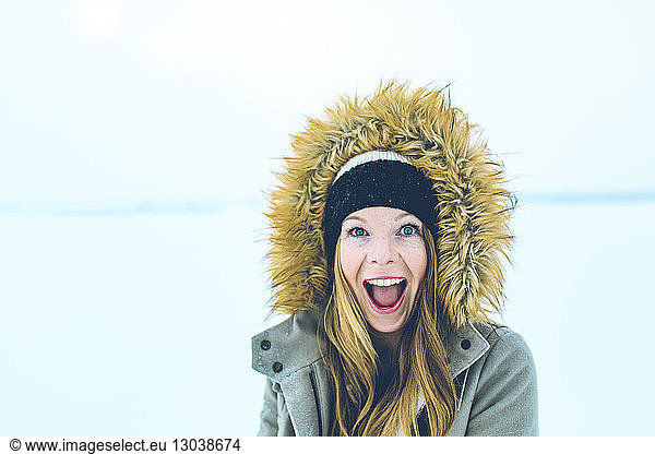 Portrait of woman with mouth open wearing fur hood during winter