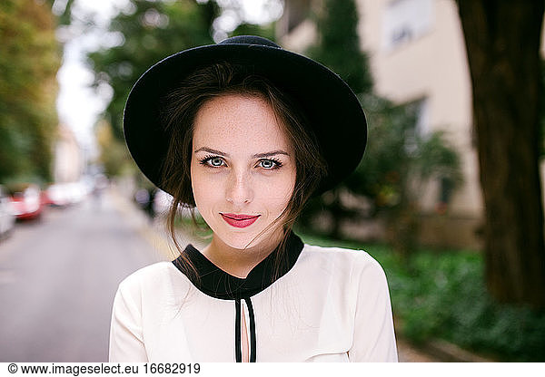 Portrait of young beatiful woman wearing black hat