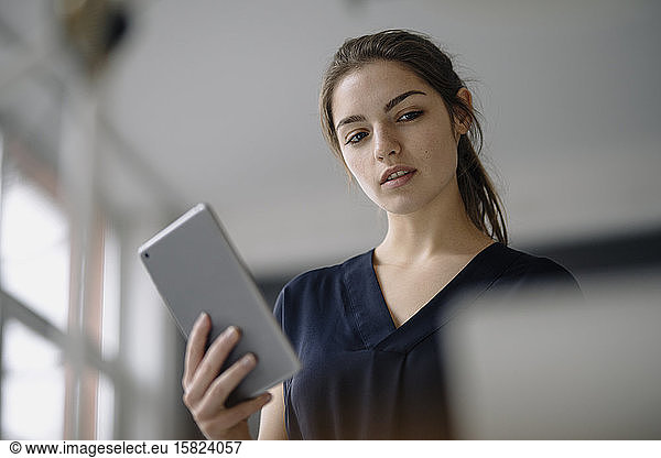 Portrait of young businesswoman with digital tablet in office