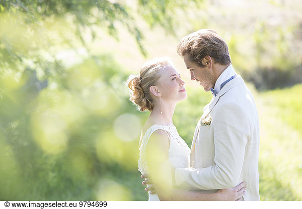 Portrait of young couple embracing in domestic garden
