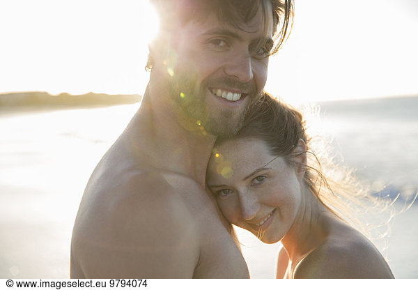 Portrait of young couple embracing on beach