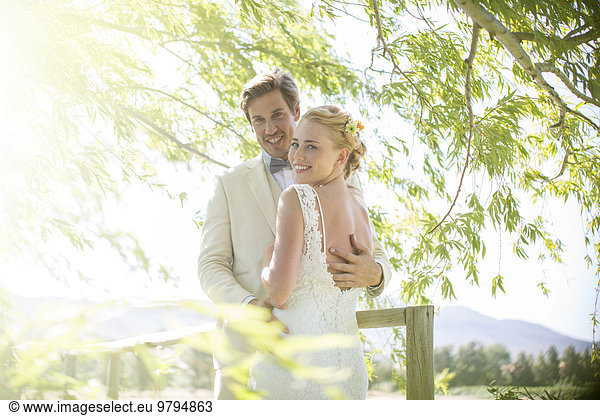Portrait of young couple embracing on wooden bridge