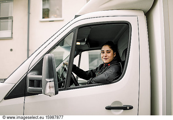 Portrait of young delivery woman driving truck