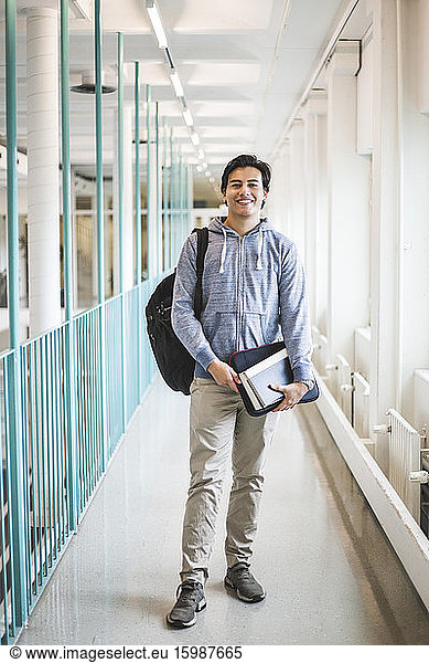 Portrait of young male student in corridor of university