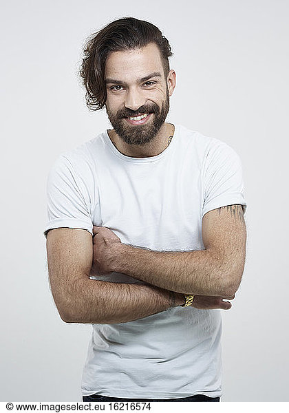 Portrait of young man against white background  smiling