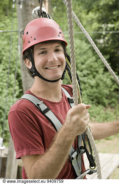 Portrait of young man climbing crag  smiling