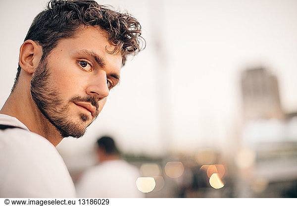 Portrait of young man exploring city during sunset