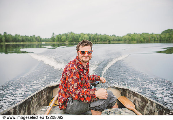 Portrait of young man in boat on lake