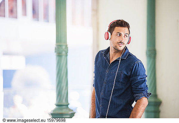 Portrait of young man listening music with headphones