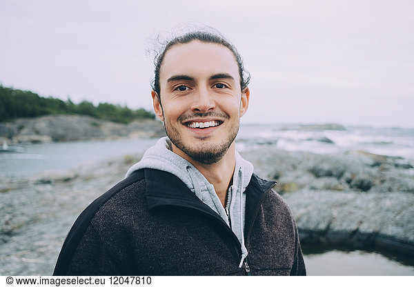 Portrait of young man smiling at beach