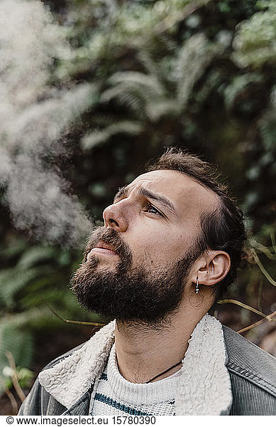Portrait of young man  smoking outdoors