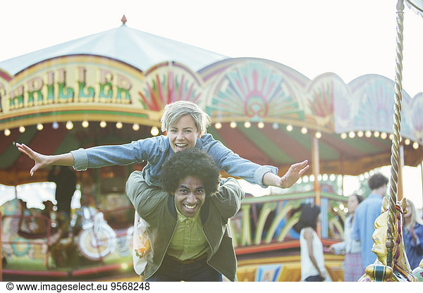 Portrait of young multiracial couple having fun in amusement park