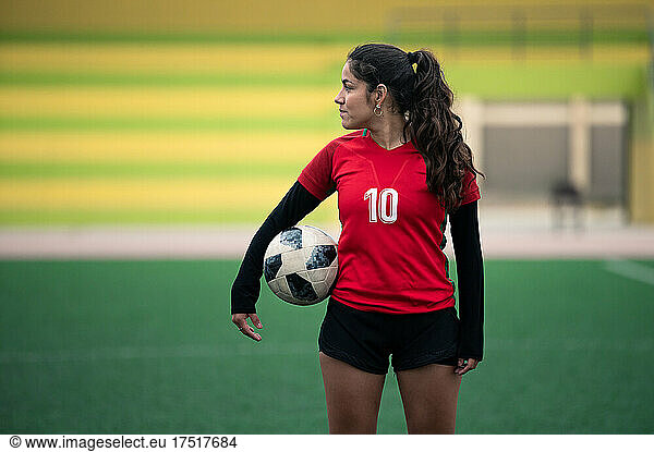 Portrait of young woman holding a soccer ball in her hand
