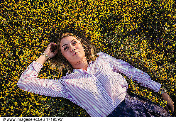 portrait of young woman laying in desert wildflower field