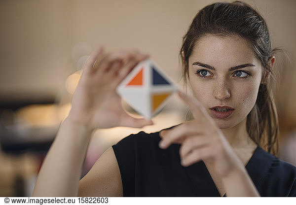 Portrait of young woman organising time management with cube