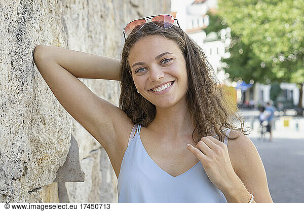 Portrait of young woman smiling at the camera in city