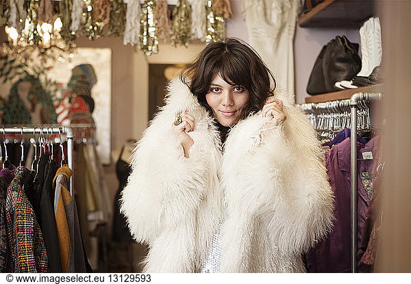 Portrait of young woman wearing fur coat at boutique