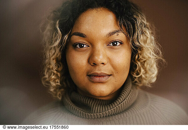 Portrait of young woman wearing turtleneck in studio