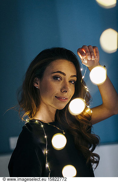 Portrait of young woman with chain of lights