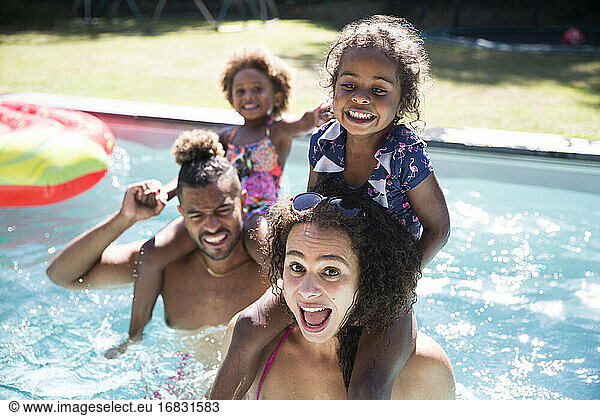 Portrait playful family in sunny summer swimming pool