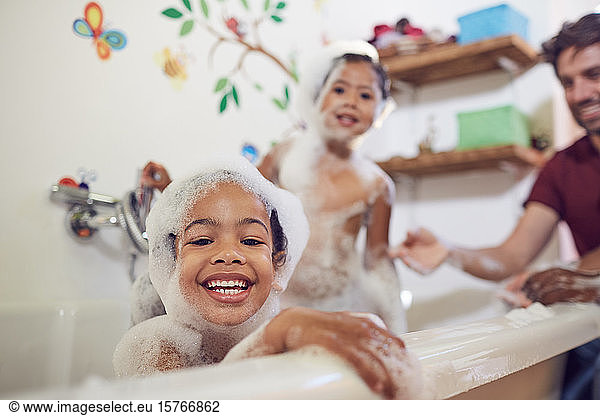 Portrait playful girls taking bubble bath