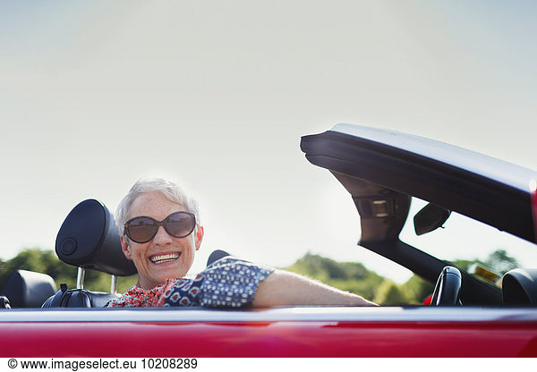 Portrait senior woman driving convertible