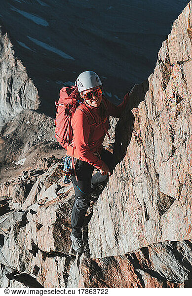 Portrait shot of female climber on exposed ridge in morning light