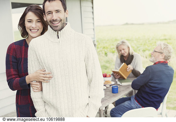 Portrait smiling brunette couple in sweaters on patio