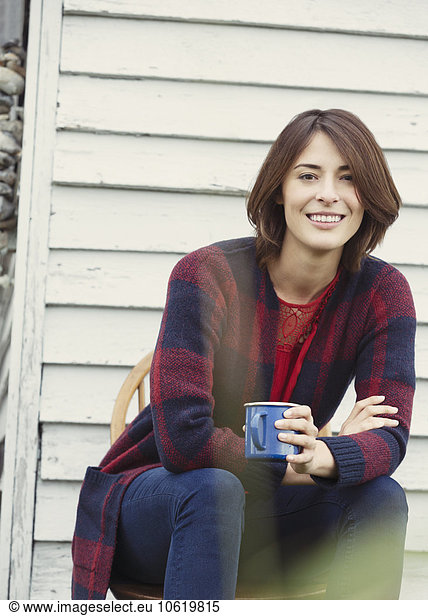 Portrait smiling brunette woman drinking coffee outdoors