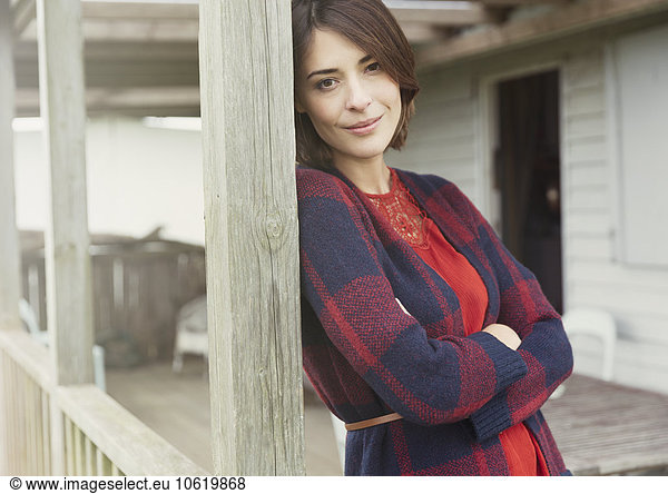 Portrait smiling brunette woman in sweater on porch