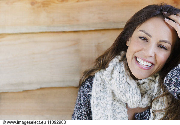 Portrait smiling brunette woman with scarf and hand in hair