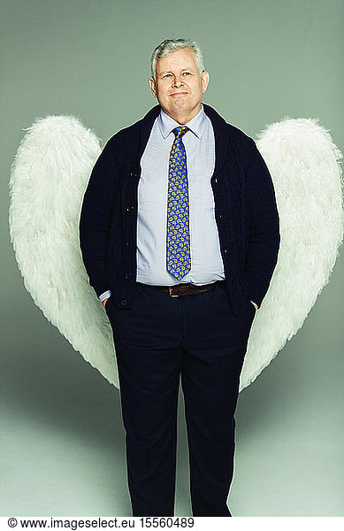 Portrait smiling businessman wearing angel wings