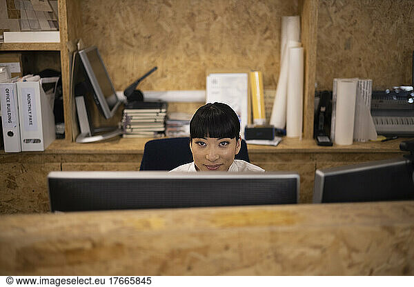 Portrait smiling businesswoman working at computer