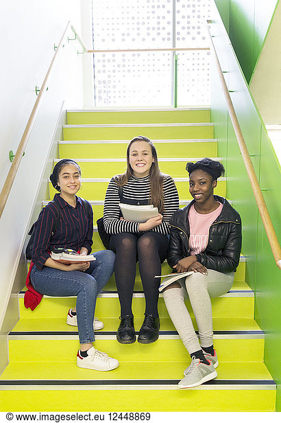 Portrait smiling confident high school girls sitting on stairs
