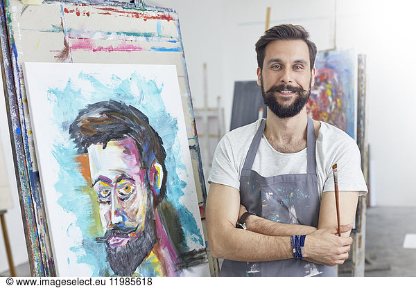 Portrait smiling  confident male artist painting in art studio