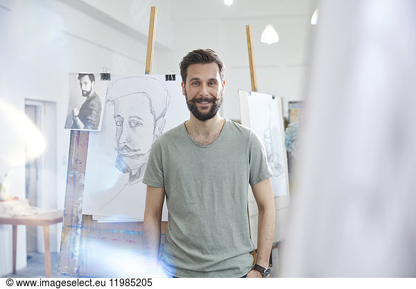 Portrait smiling  confident male artist sketching in art class studio