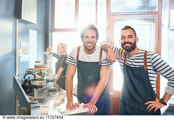 Portrait smiling  confident male coffee roasters tasting coffee