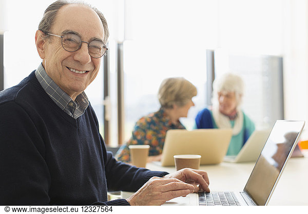 Portrait smiling  confident senior businessman using laptop in conference room meeting